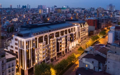 aerial-view-of-a-horizontal-residential-building-in-the-street-with-trees-and-buildings-of-istanbul-in-the-background-in-the-evening