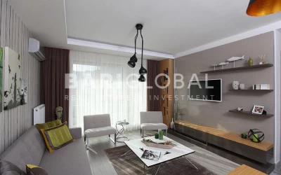 living-room-with-gray-sofa-white-armchairs-patterned-walls-a-tv-unit-black-pendant-lights-square-coffee-table-and-decorative-items